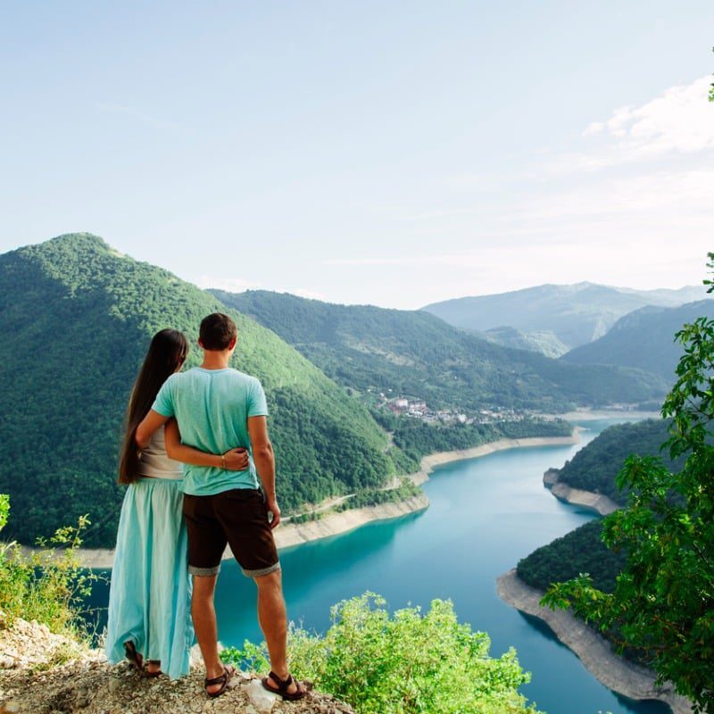 Couple-Overlooking-Valley-From-Mountain-Top-In-New-Zealand